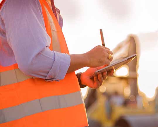 A crane inspector using a digital tablet to record their data into Cranes101's Customer Safety Management Portal.